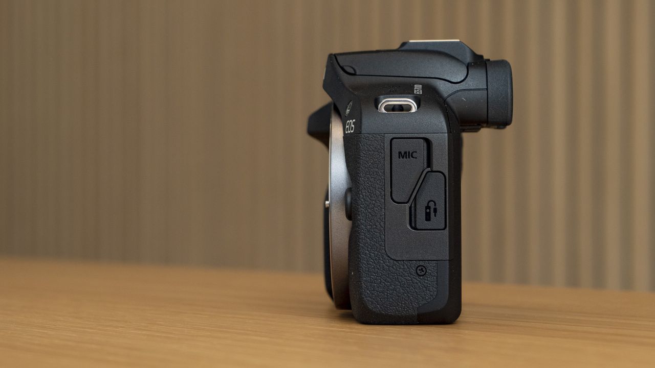 Canon EOS R100 camera on a table side profile
