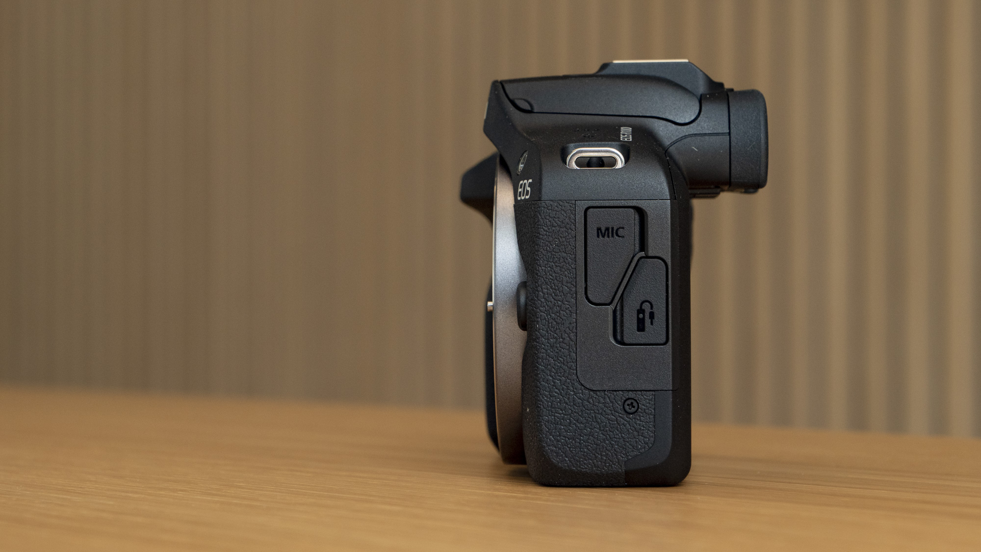Canon EOS R100 camera on a table side profile