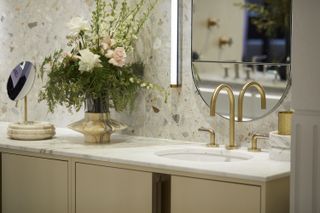 A beige bathroom cabinet with white counter top and tiled backsplash
