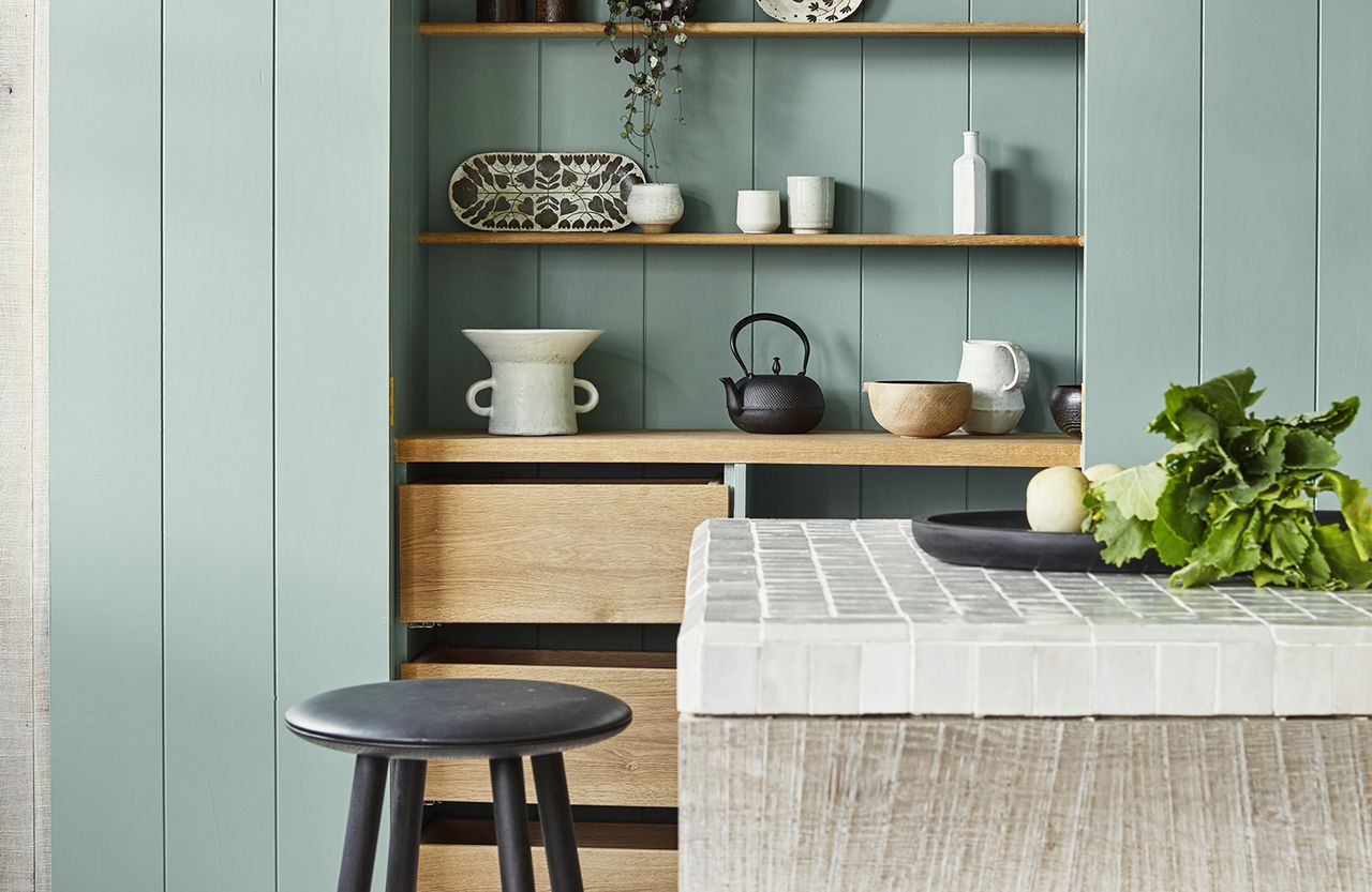 pastel kitchen with green cabinets and wood island