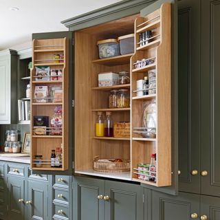 green panelled kitchen with pantry and gold hardware