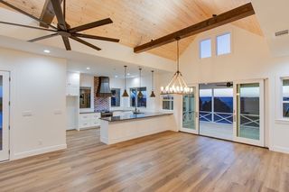 Living area and kitchen with wood floor and vaulted ceiling