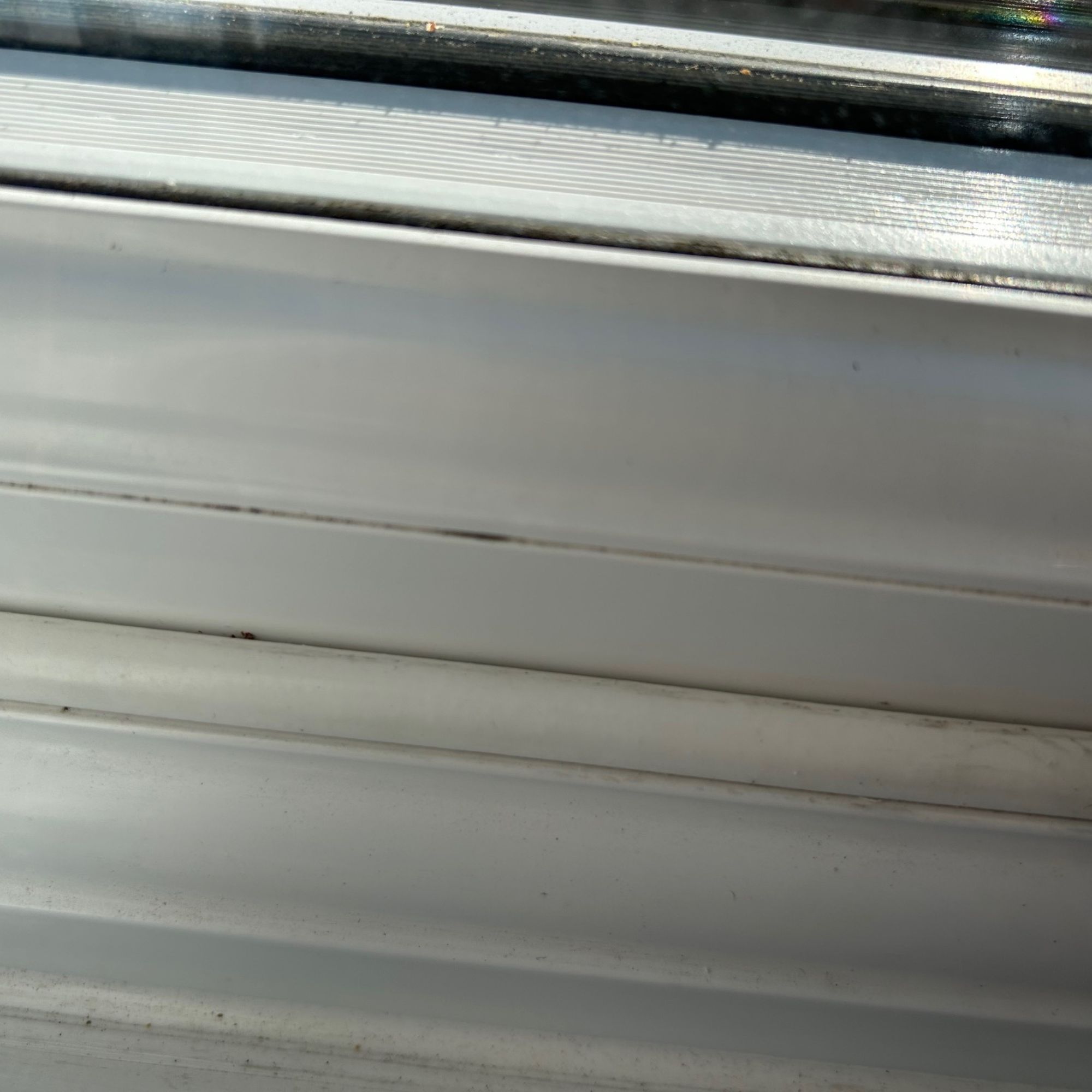 Draught proofing strip attached to white uPVC window