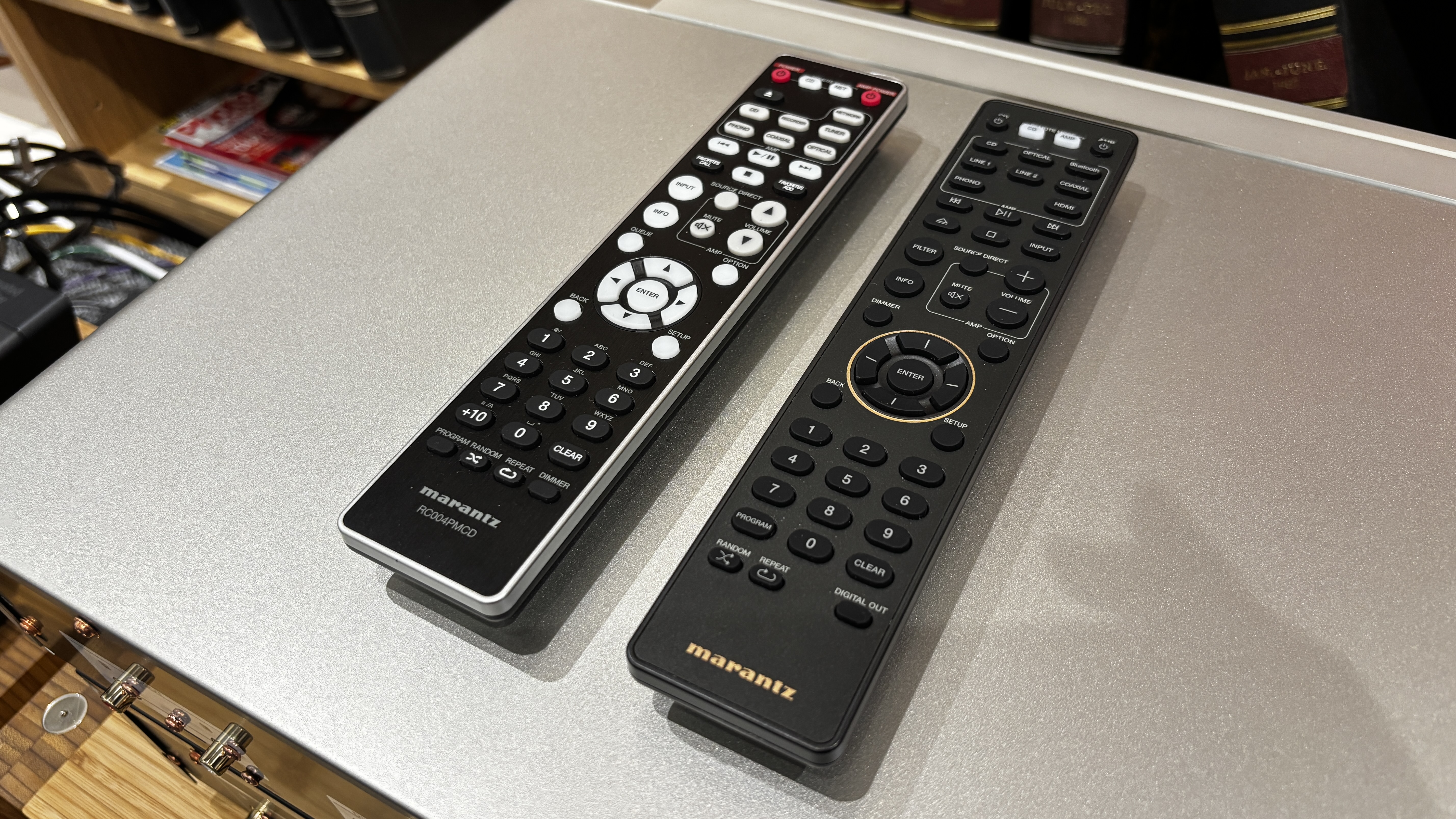 The remote controls for a Marantz CD 70 and CD6007 placed on top of a metal surface