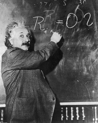 albert einstein writing on a chalkboard