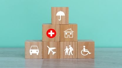Wooden building blocks with an umbrella, wheelchair and car symbols on them.