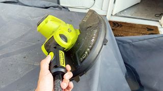 Sun Joe 24V-ST14 Cordless String Trimmer being tested in writer's home