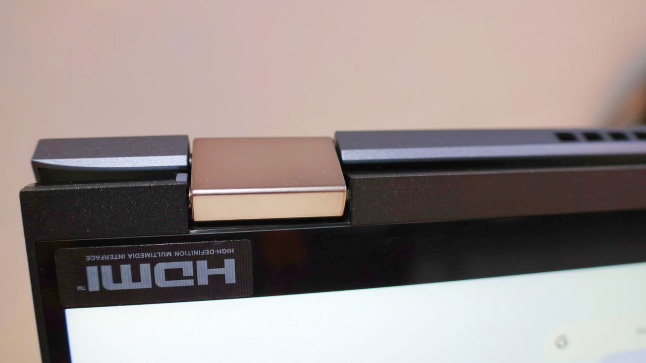 Close up of the Acer Chromebook Spin 714's convertible hinges against a pink background.
