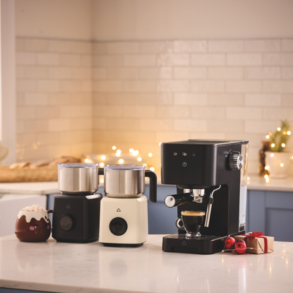Aldi hot chocolate maker and espresso machine on a white kitchen island.
