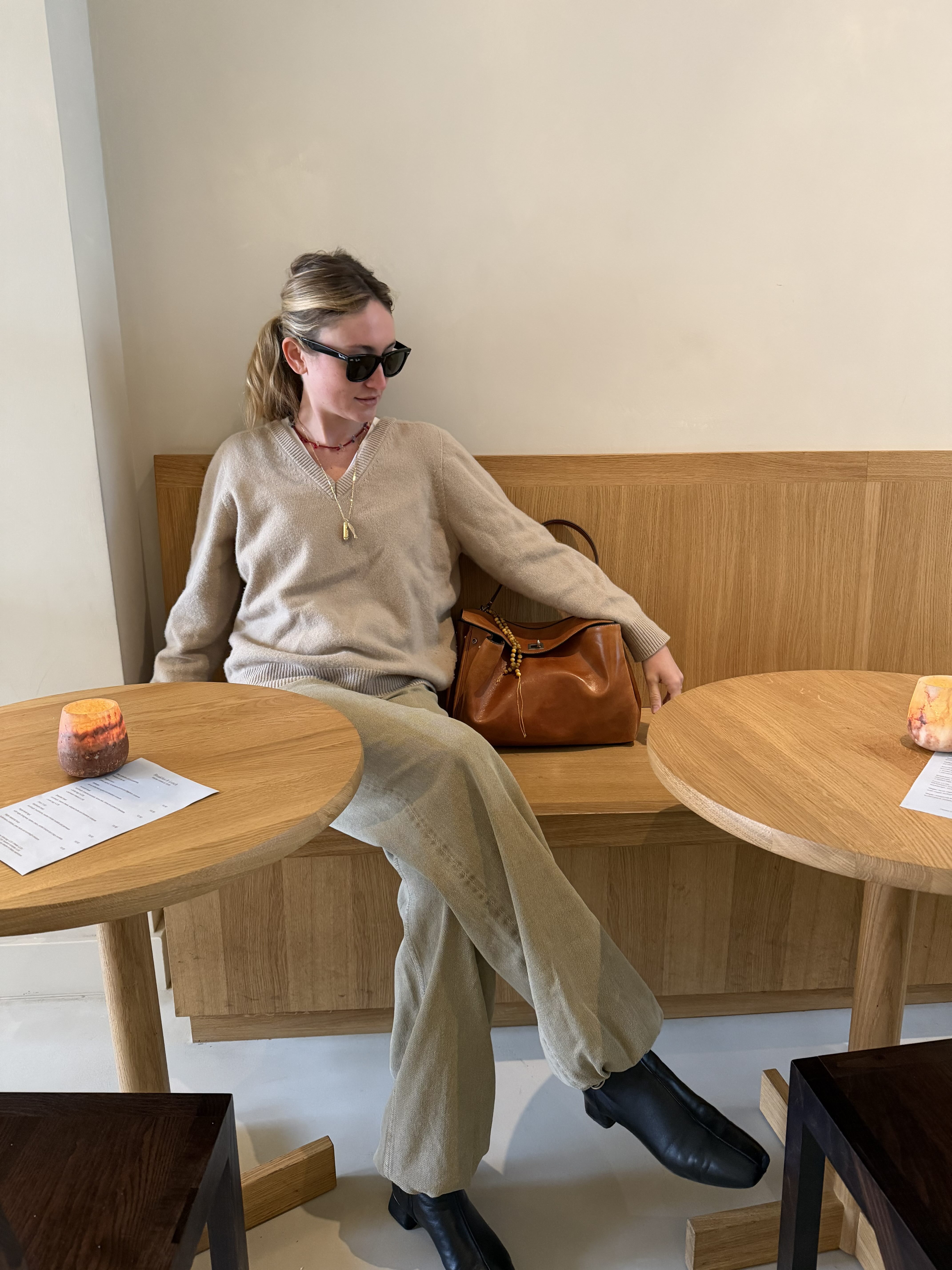 Cassidy Crockett in a brown seater, tan pants, black boots, and a brown Balenciaga Rodeo Bag