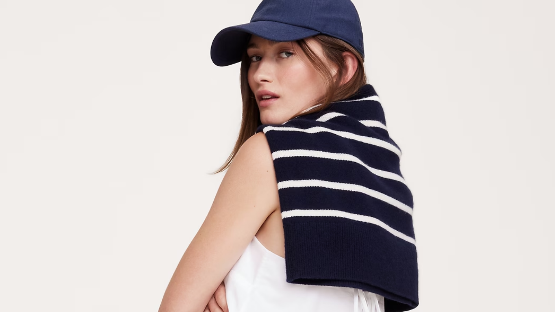 woman wearing a blue baseball cap and a striped sweater