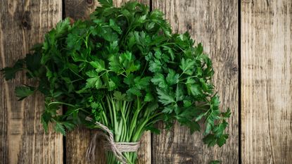 bunch of parsley on a wooden chopping board