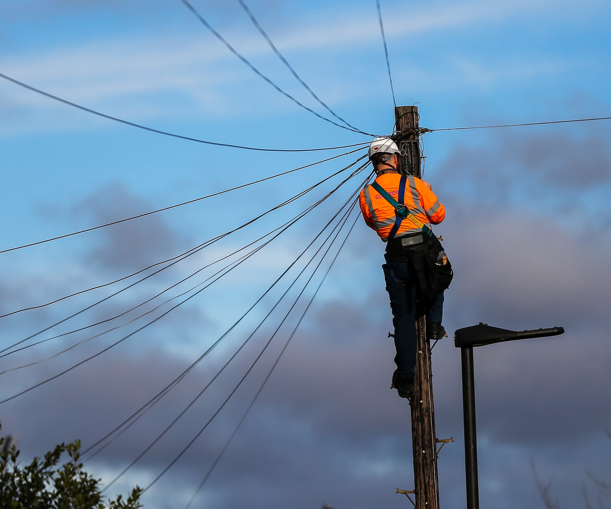 An Openreach engineer installing broadband on a pole