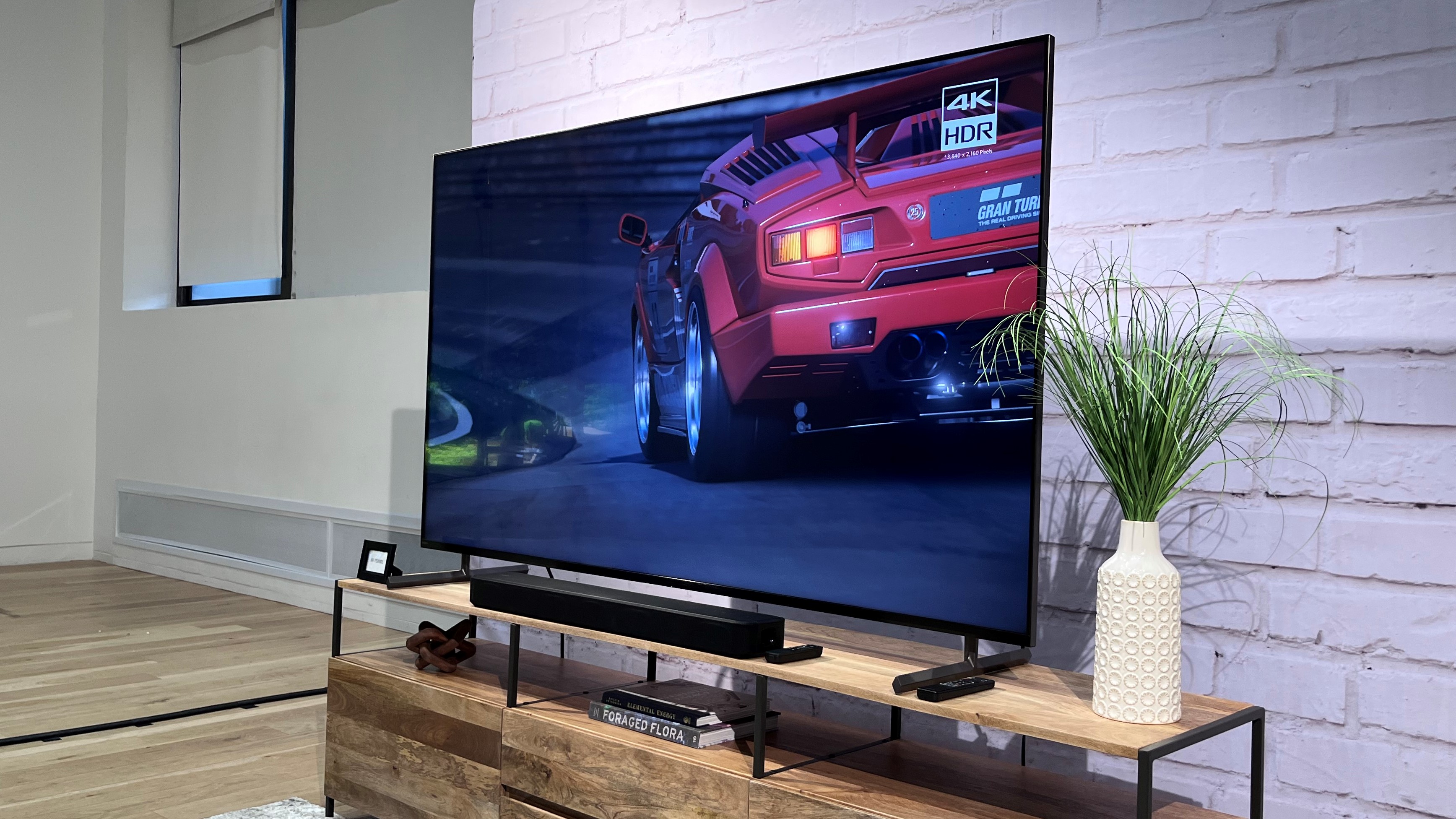 TV Sony XR-X90L em suporte de TV de madeira com barra de som