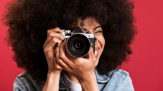 Black woman taking photo on vintage camera