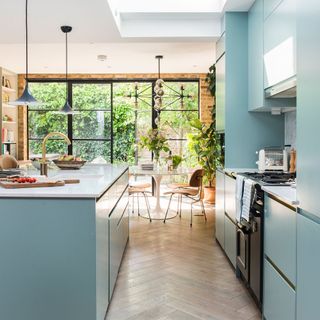 Powder blue kitchen in a light filled extension with a tulip table in the background