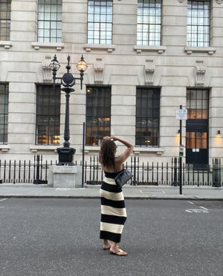 Jasmine Fox-Suliaman wearing a stripe Posse maxi dress, Freja Caroline Bag, and Tory Burch Patos Sandals