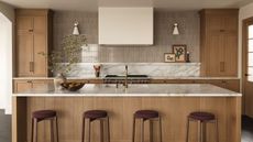 A wooden kitchen with a marble countersplash that flows into warm neutral wall tiles