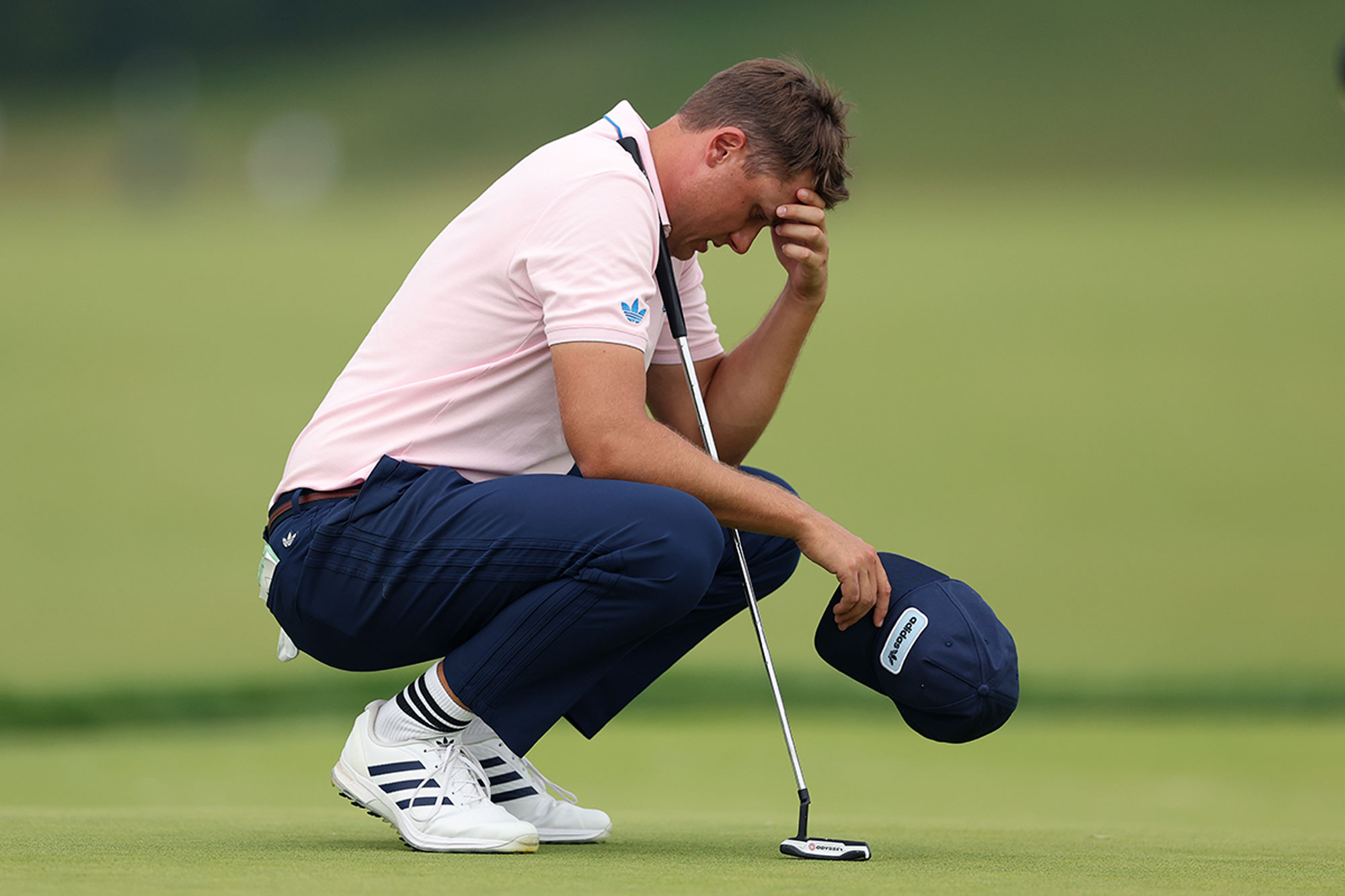 Ludvig Aberg on his haunches with his head in his hands while playing the tough Oakmont Country Club at the US Open