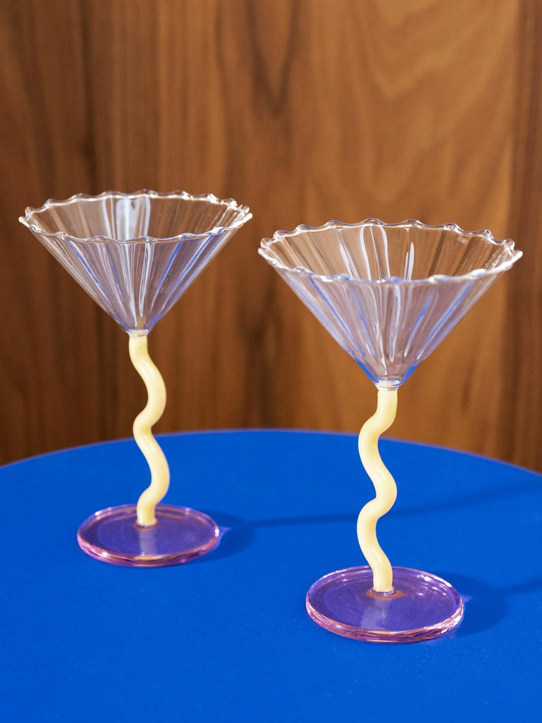 A pair of rippled martini glasses with curved yellow stems and a pink base from &amp;amp;Klevering