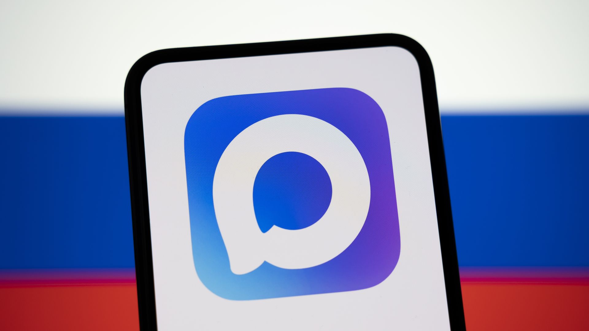 The Max logo appears on a smartphone screen with the Russian flag in the background