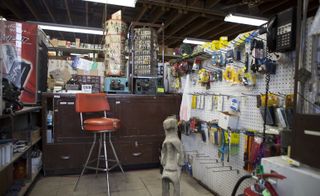 Inside a hardware store with dark brown counter and leather upholstered stool