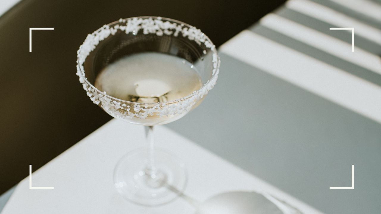 Half-drunk martini glass of alcohol with salted rim sitting on sunlit table, representing what happens when you give up alcohol