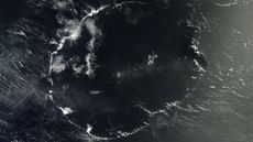 A satellite image of a thin wispy ring of clouds above the ocean