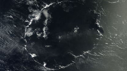 A satellite image of a thin wispy ring of clouds above the ocean