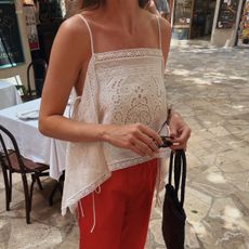 Woman in a white top and red pants