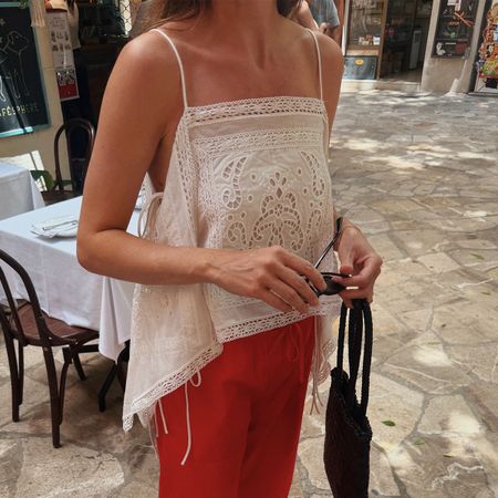 Woman in a white top and red pants