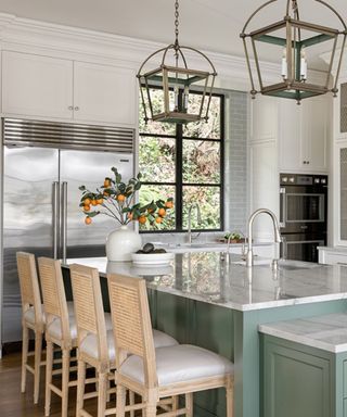 White kitchen with green kitchen island with marble countertop