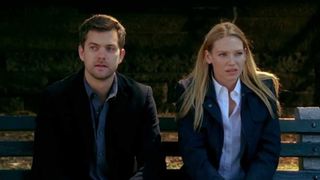 a man and a woman sit on a park bench looking confused in the tv show fringe