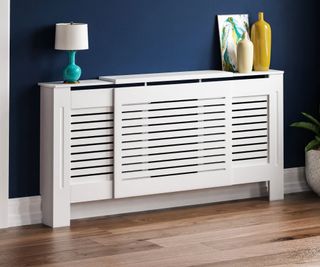 slatted white adjustable radiator cover with navy blue wall