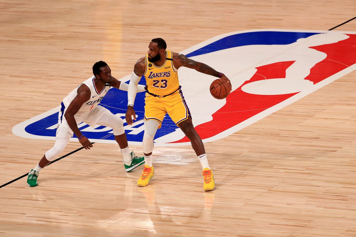 LeBron James #23 of the Los Angeles Lakers dribbles the ball against Reggie Jackson #1 of the LA Clippers of the game at The Arena at ESPN Wide World Of Sports Complex on July 30, 2020 in Lake Buena Vista, Florida.