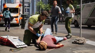 An EMT checks the pulse of a wounded individual in Ambulance Life: A Paramedic Simulator.