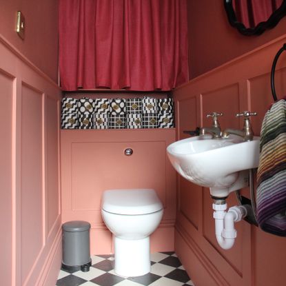 Tiny downstairs loo with red painted wall-panelling and checkerboard floor tiles