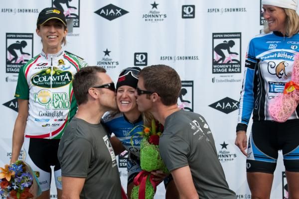 Kristen McGrath (Peanut Butter &amp; Co/Team Twenty12) gets the celebratory kisses from the Aspen Pro Women's Stage Race Podium Boys as Janel Holcomb and Kristin Armstrong look on.