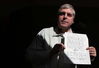 Chicago Police Lt. John Lewison, at his Chicago home, March 25, 2011, spreads out copies of a map, codes and other clues left behind by a notorious killer