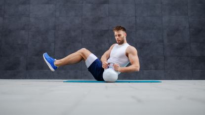 A man performing a core workout with a kettlebell