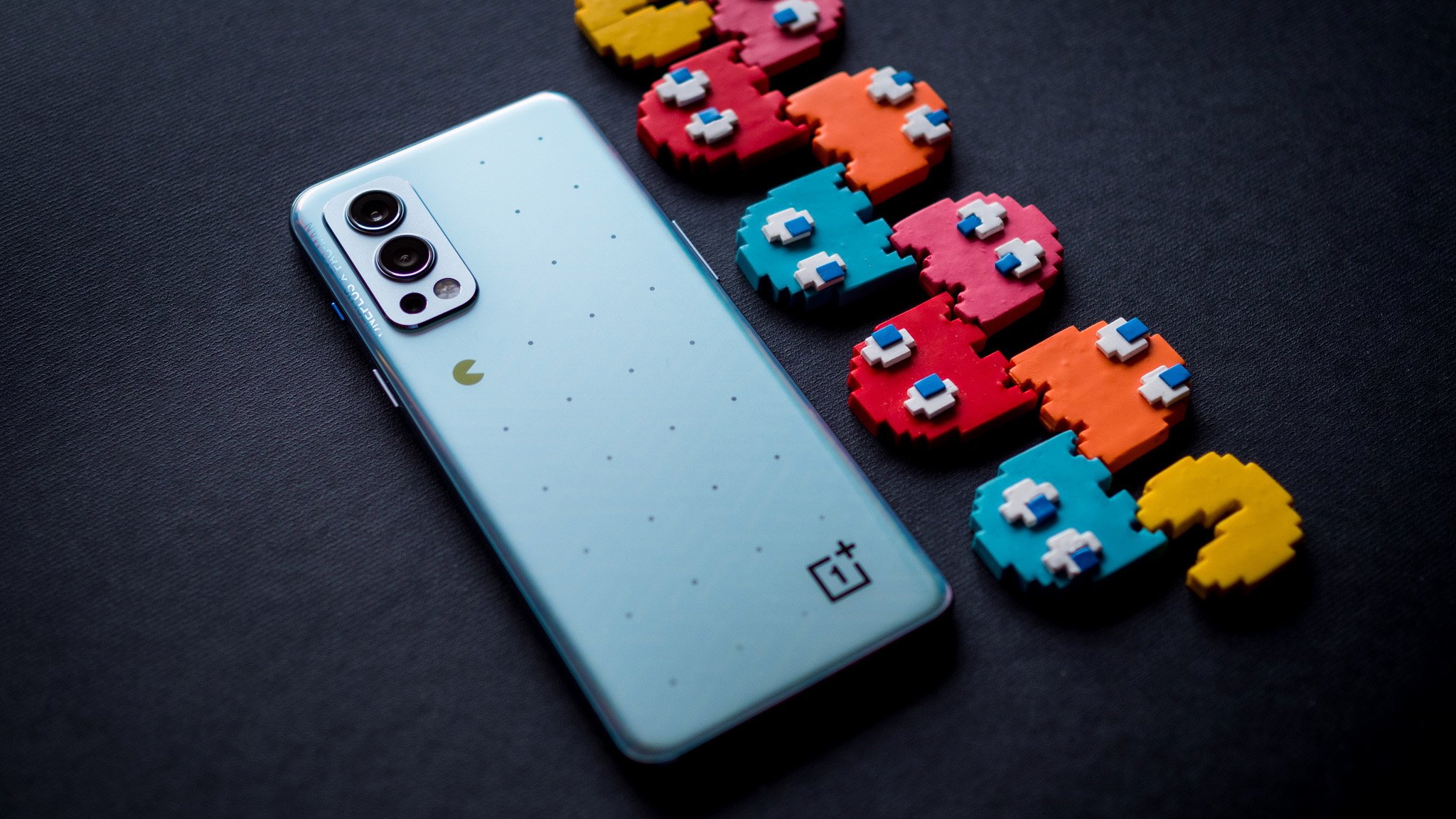 The OnePlus Nord 2 X PAC-MAN edition phone sitting next to Pac-man ghosts