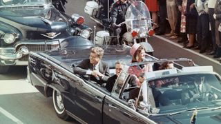 President John Kennedy rides in a motorcade from the Dallas airport into the city with his wife Jacqueline and Texas Governor John Connally.