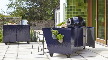 an outdoor pizza station with potted herbs