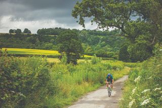 Male cyclist riding outside on a country lane