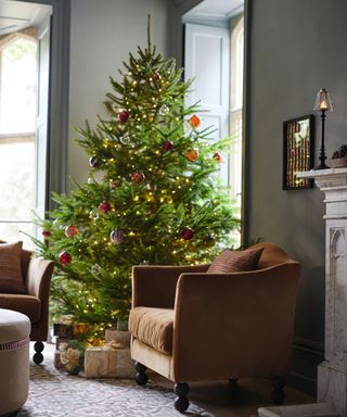 living room with christmas tree with minimalist red decorations and warm-toned lights