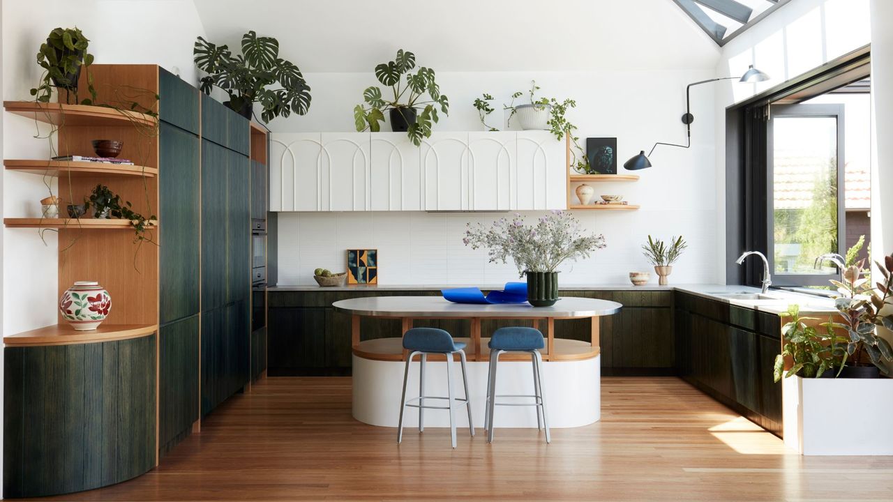 An organized kitchen with lots of green foliage 