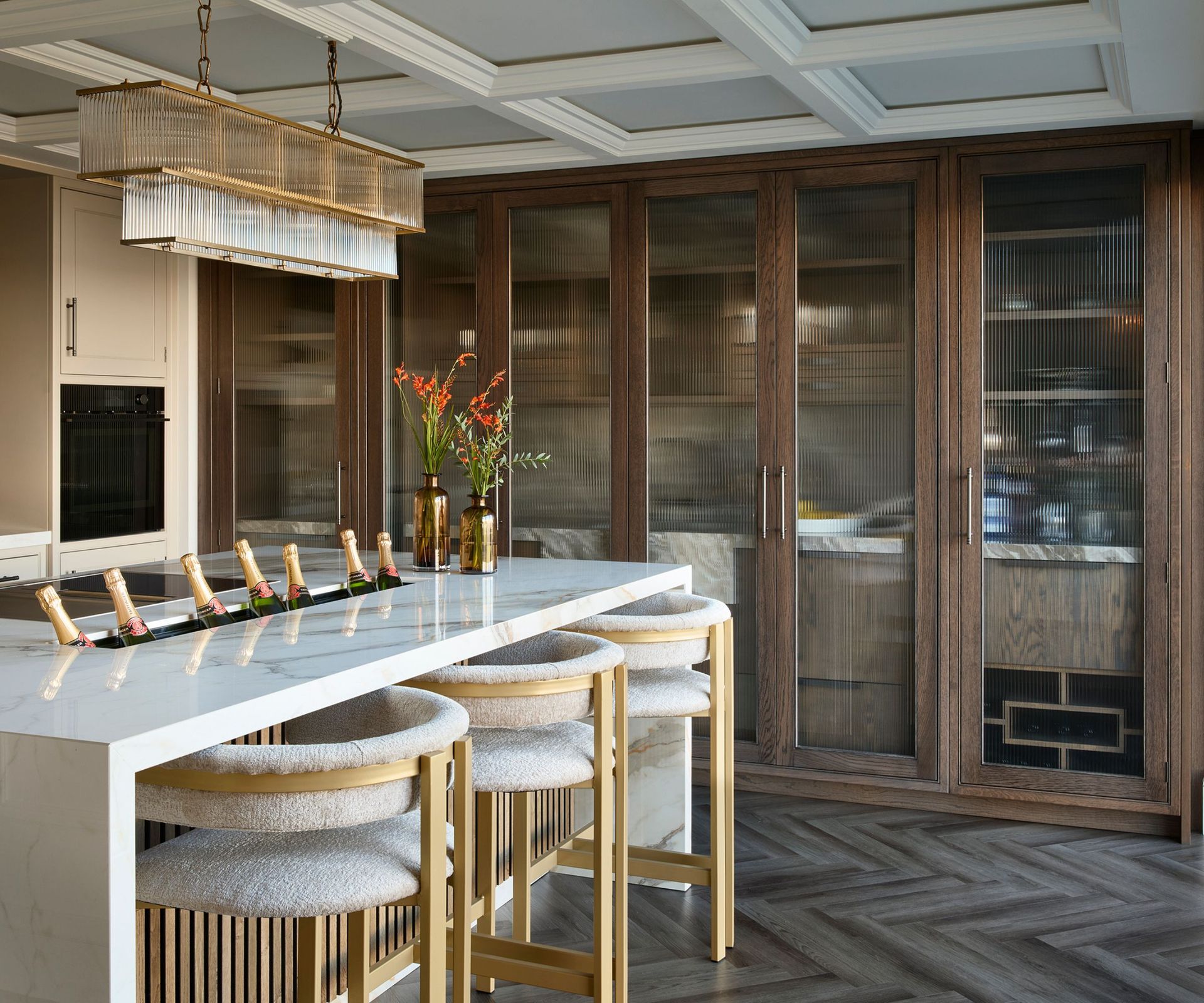 An art-deco inspired kitchen with wooden cabinets and marble countertops