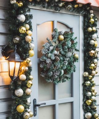 Winter rustic entrance door decorated for New year and Christmas with ornaments and Christmas lights