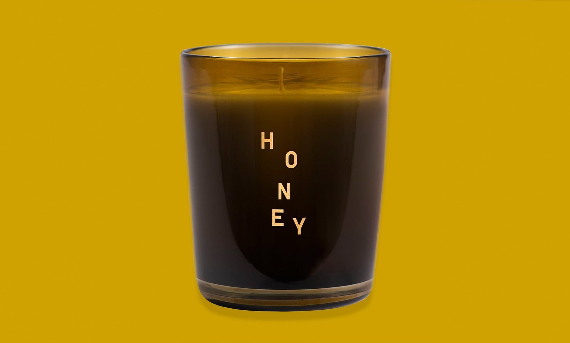 glass candle holder on yellow background