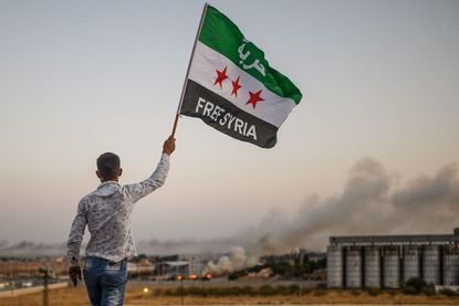 A man waves an opposition flag in Syria.